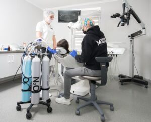Dentist and assistant performing dental procedure with modern equipment in Kiev clinic.